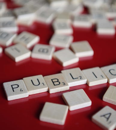 Weisse Scrabble-Bausteine «PUBLICA» auf rotem Grund